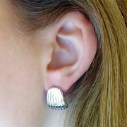 Hoop it up! Designed for everyday, these lightweight shell dome studs are a staple for your jewelry box. They shimmer with a high polish finish and feel light as a feather. So comfy and chic, you'll never want to take them off. The earrings are secured with a hinge snap. More Details: - Carefully Handmade - 100% Hypoallergenic - Stainless Steel (Anti-Tarnish) - Size: H: 17 mm W: 13 mm - Metal Color: 14k Gold, Silver